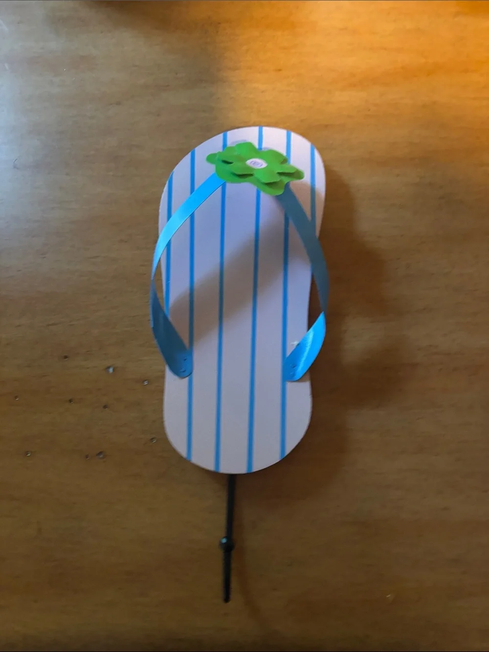 Kids Blue Striped Flip-Flops with Green Flower Accent wall hanger.